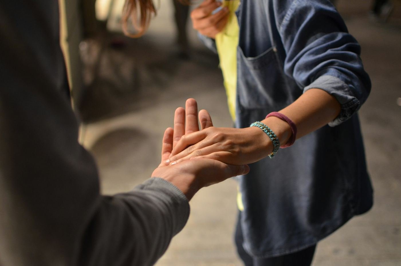 Two people joining hands in support